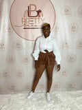 A brown bottom with a white bloused-style top, combining chic and casual vibes for a perfect look.

