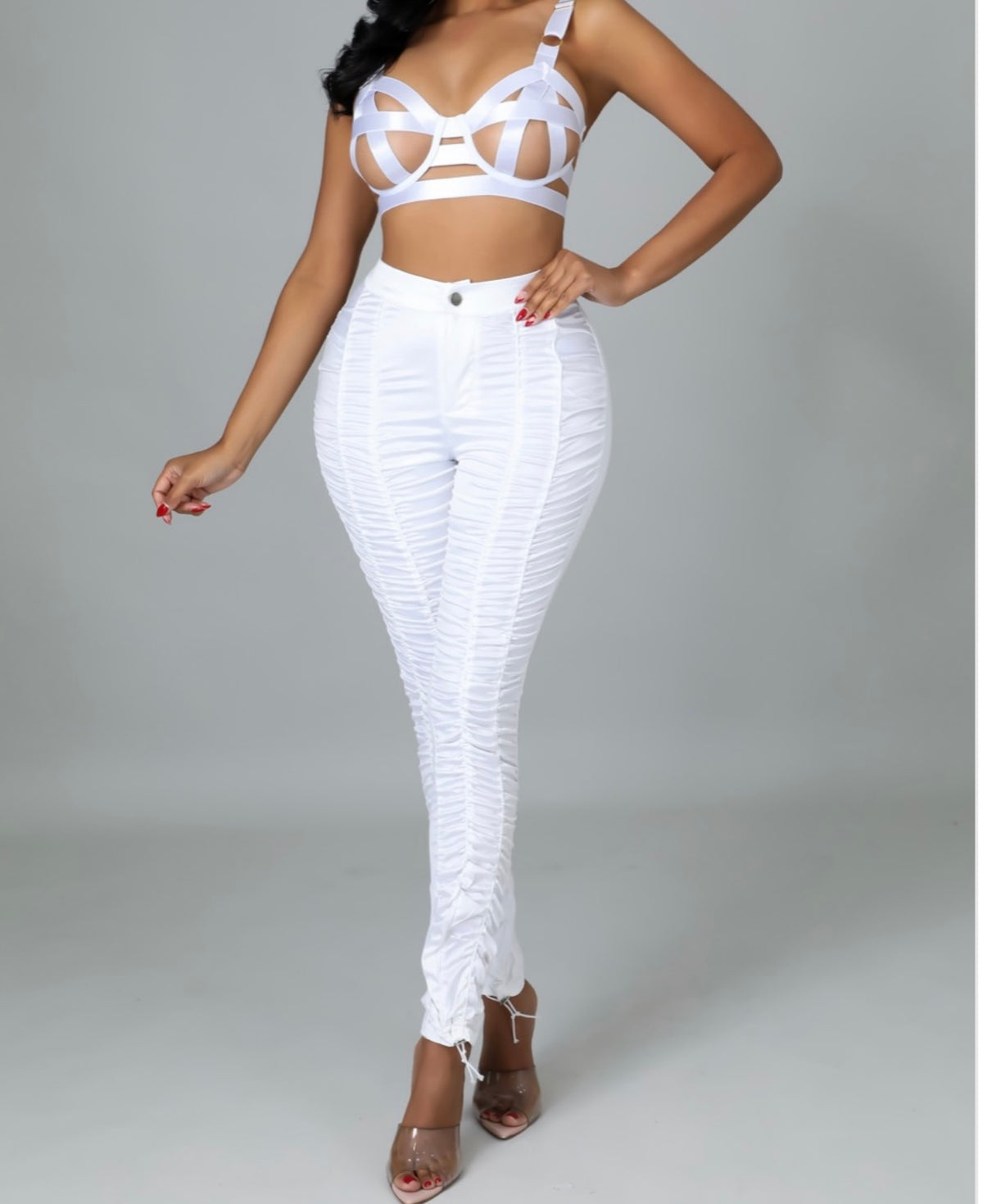 This two-piece set features a bandaged bra with adjustable straps, underwired support, and a hook and eye closure for the perfect fit. The high-waisted pants are ruched with a drawstring and a button zipper closure for a sleek, flattering look.